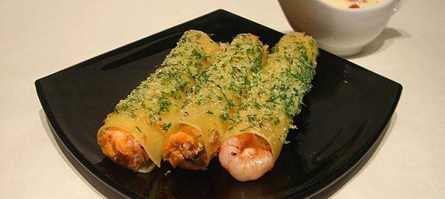 каннеллони с лососем,морским коктейлем и сливочным соусом с томатами