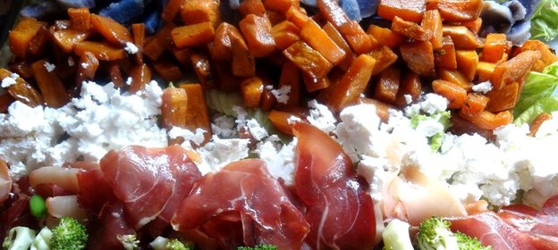 Слоеный овощной салат с прошутто и фетой на доске